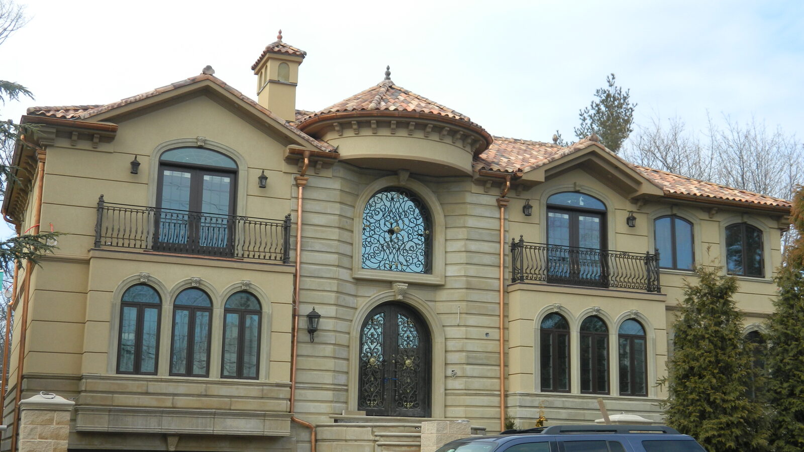 Tuscan-style villa with arched windows and clay tile roof