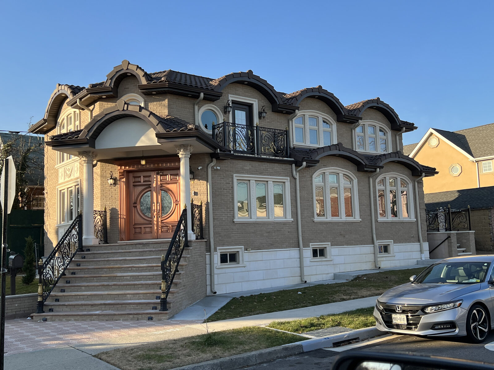 Ornate Mediterranean home with grand double staircase and clay tile roof