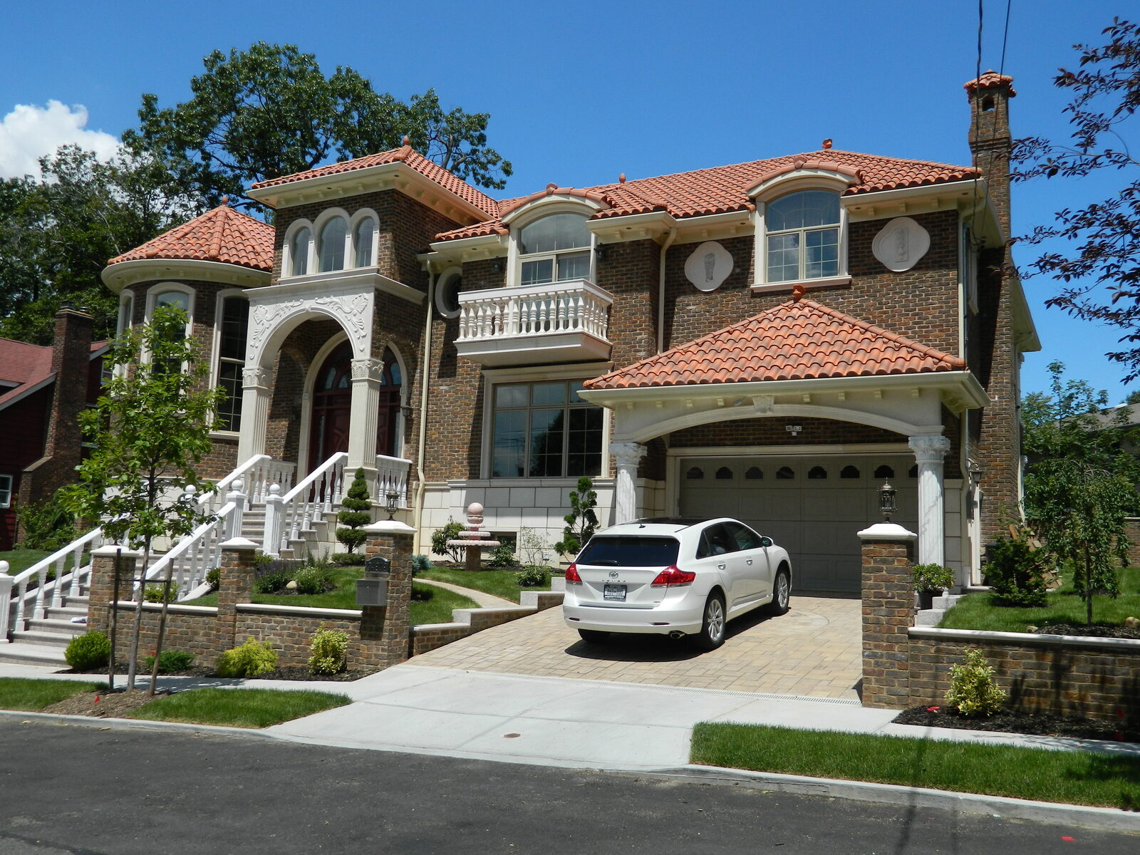 Stucco home with columns and terracotta clay tile roof