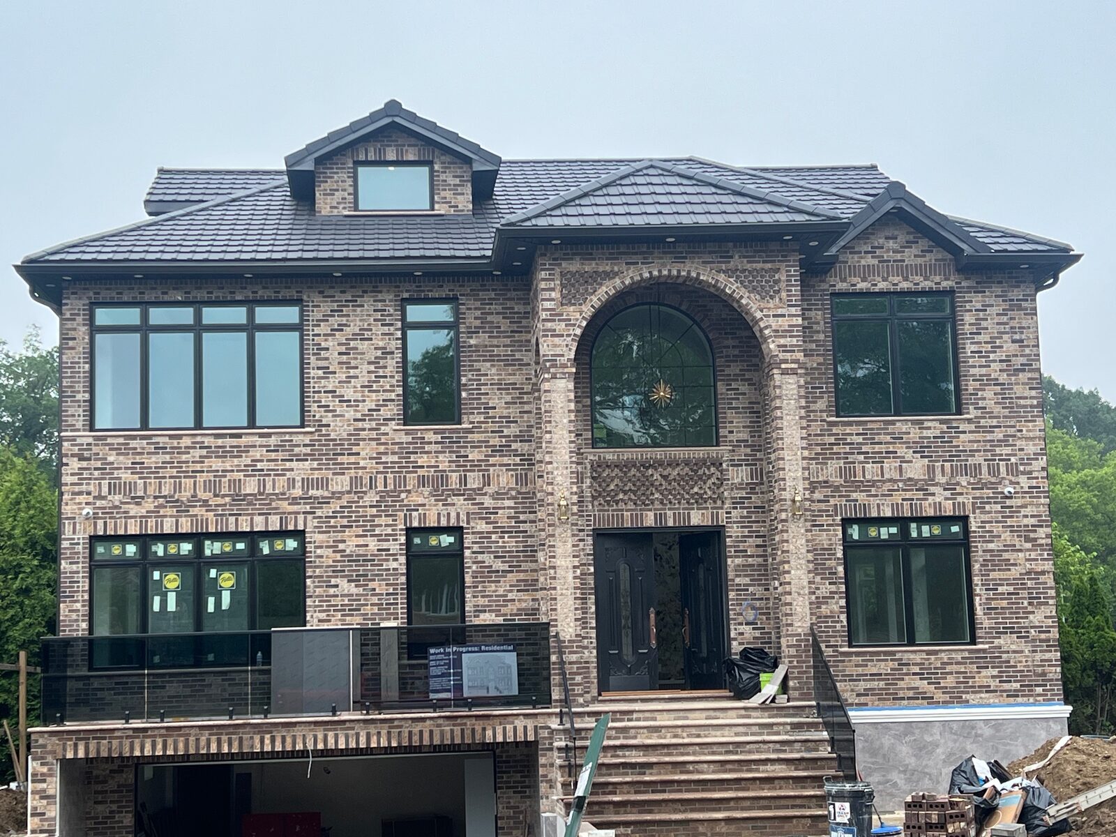 Grey-brick mansion with dark slate-toned clay tile roof