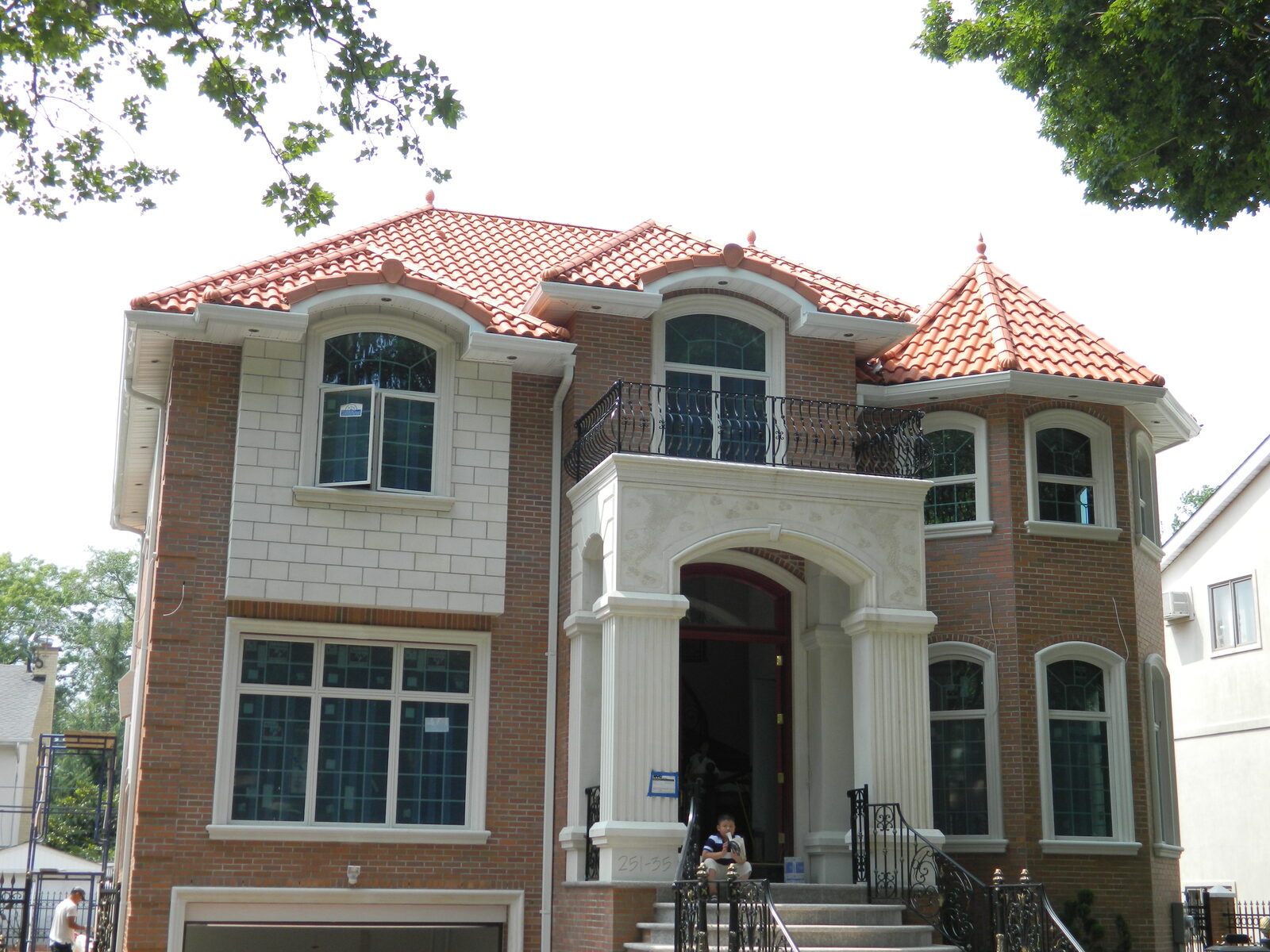 Brick home with corner turret and red clay tile roof