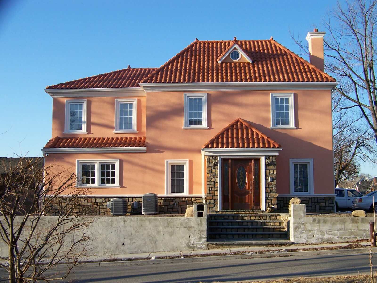 Three-story stucco home with terracotta clay tile roof