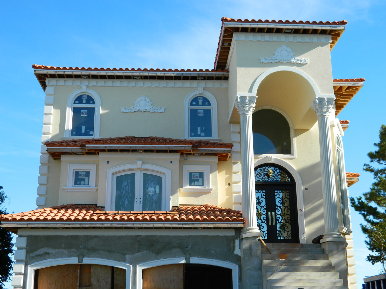 Three-story cream villa with terracotta clay tile roof