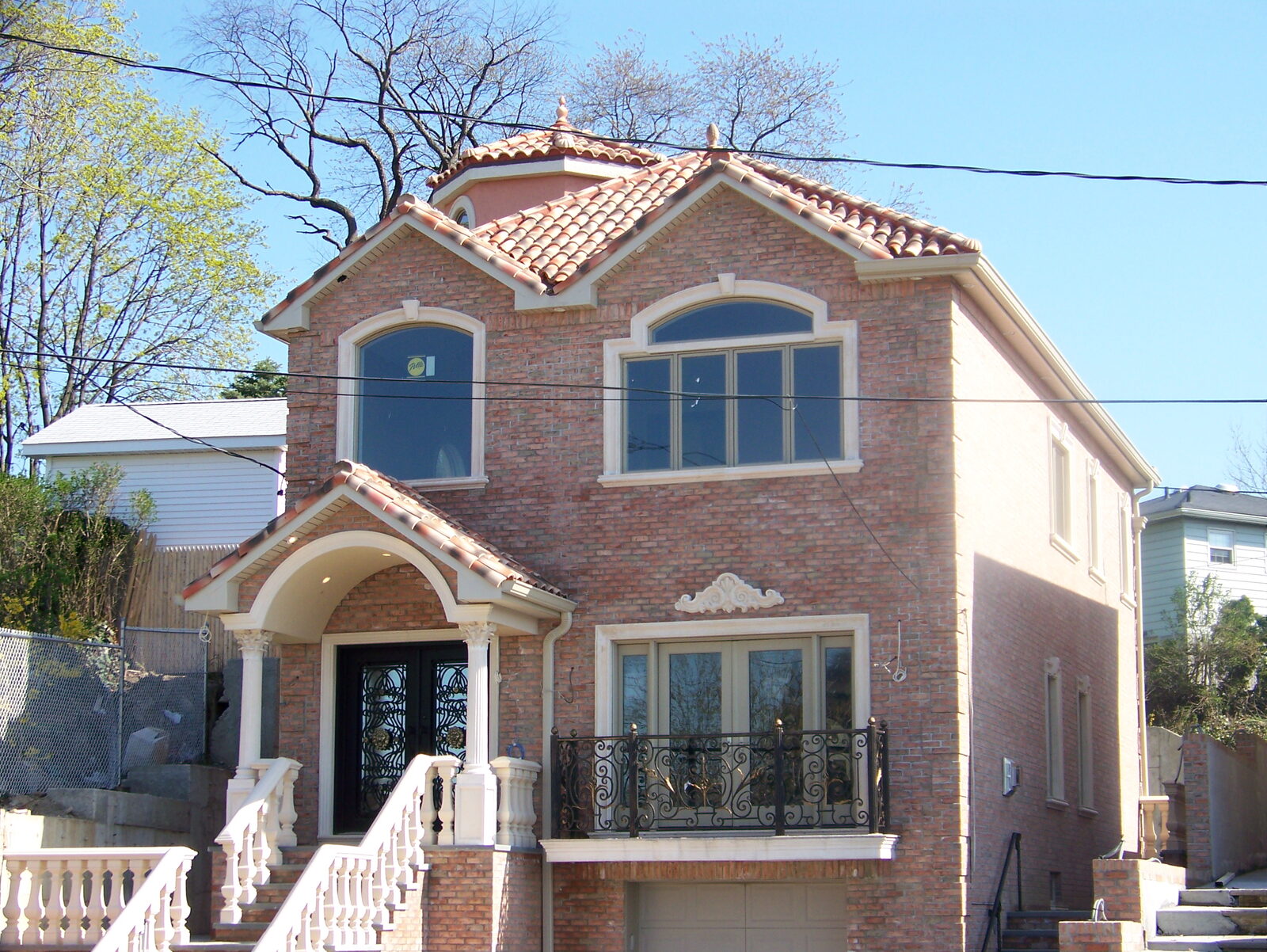 Brick home with blue-trimmed windows and clay tile roof