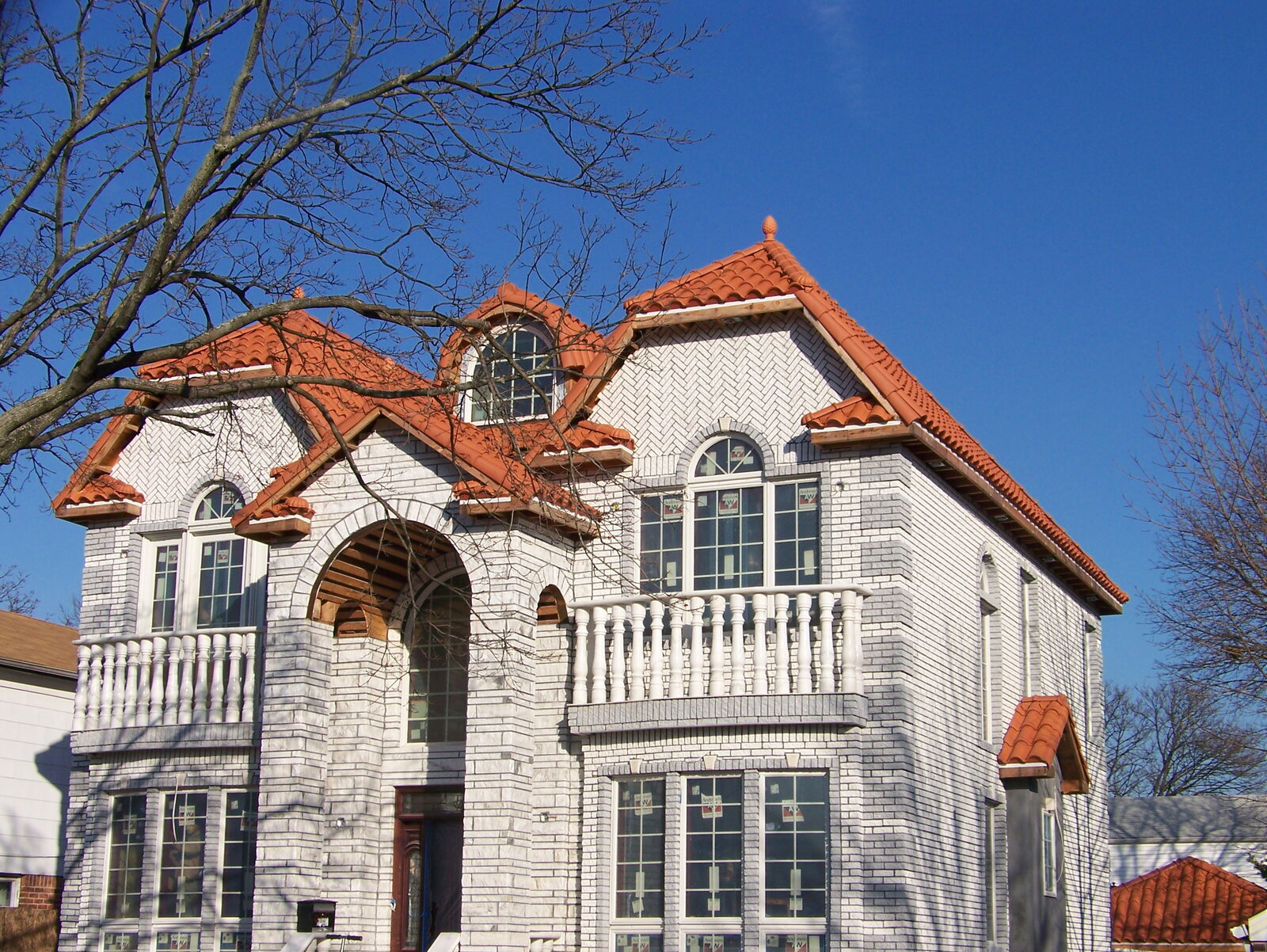 Ornate brick home with red clay tile roof