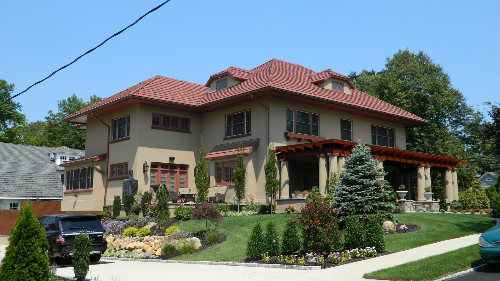 Brick mansion with landscaped gardens and red clay tile roof