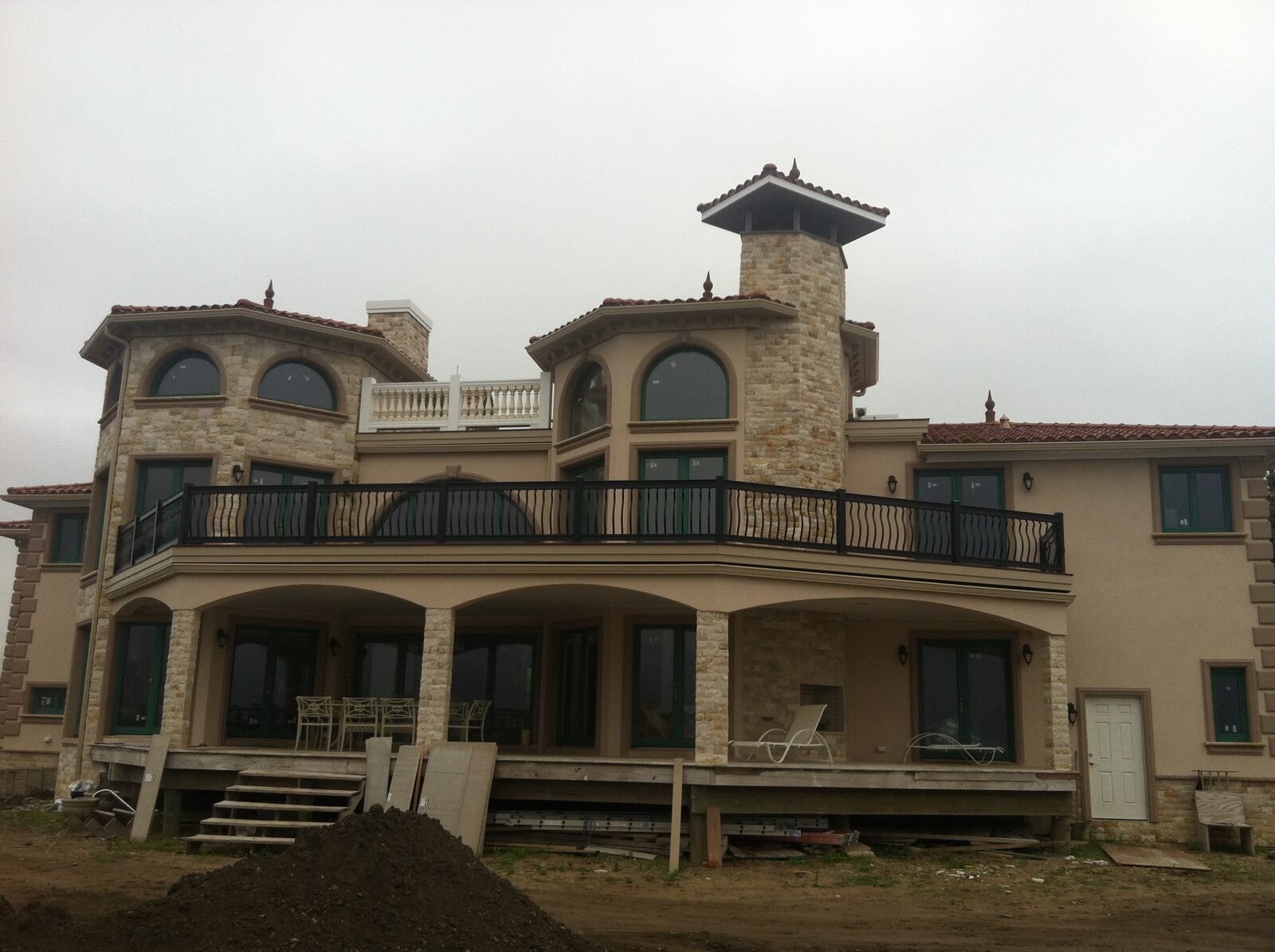 Stucco home with corner turret and glazed clay tile roof