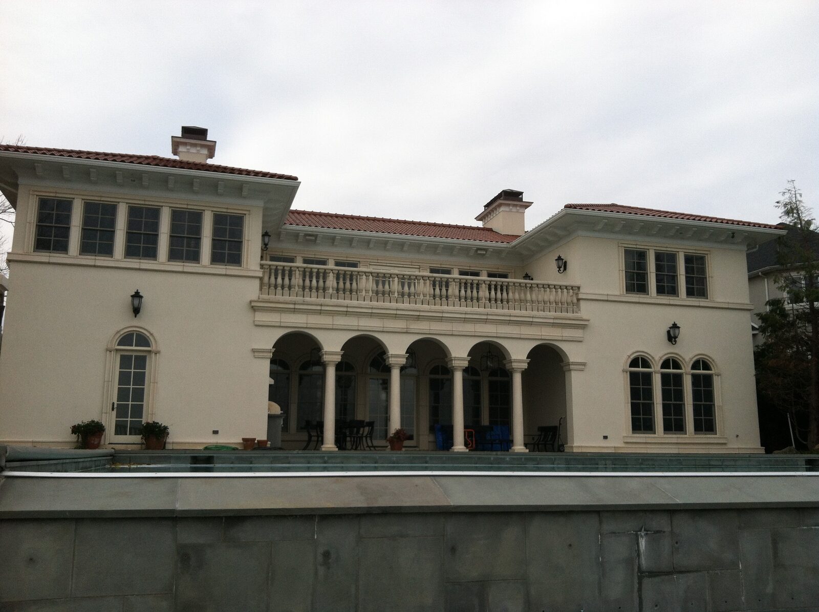 Stucco villa with arched loggia and terracotta clay tile roof