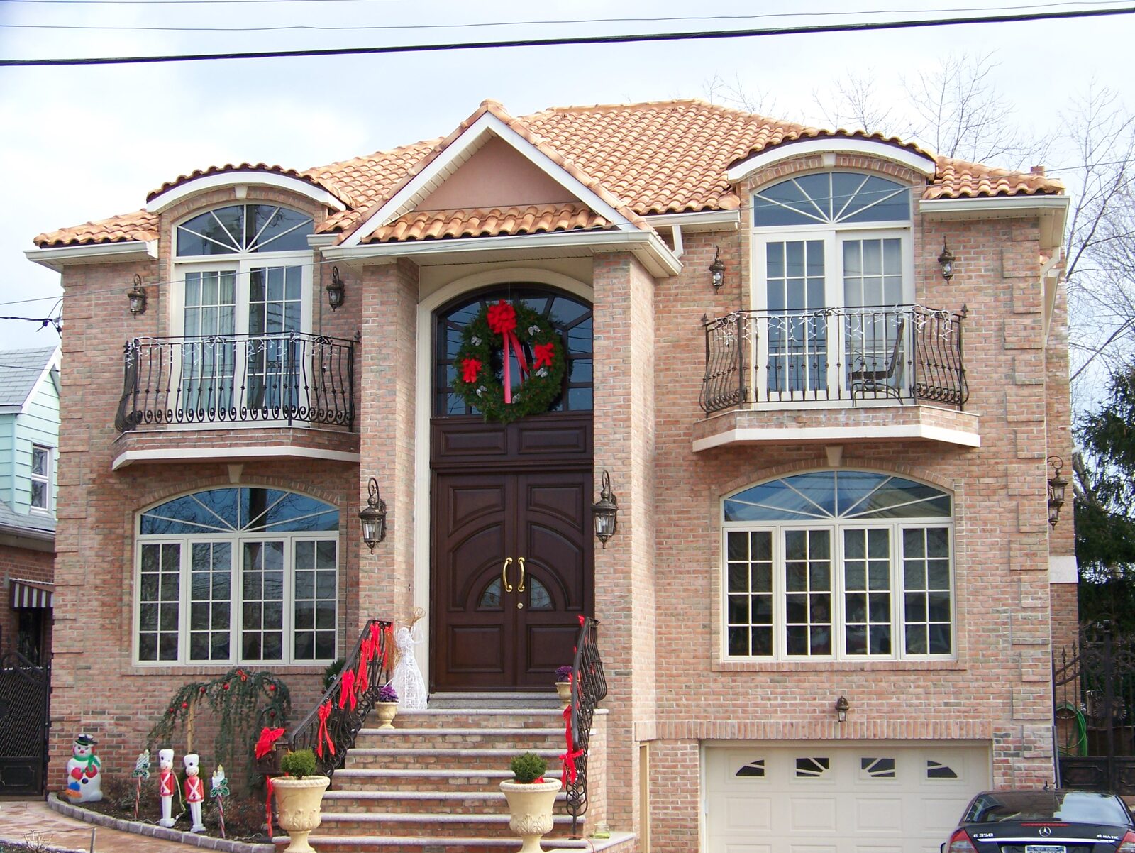 Pink-stucco home with balconies and red clay tile roof