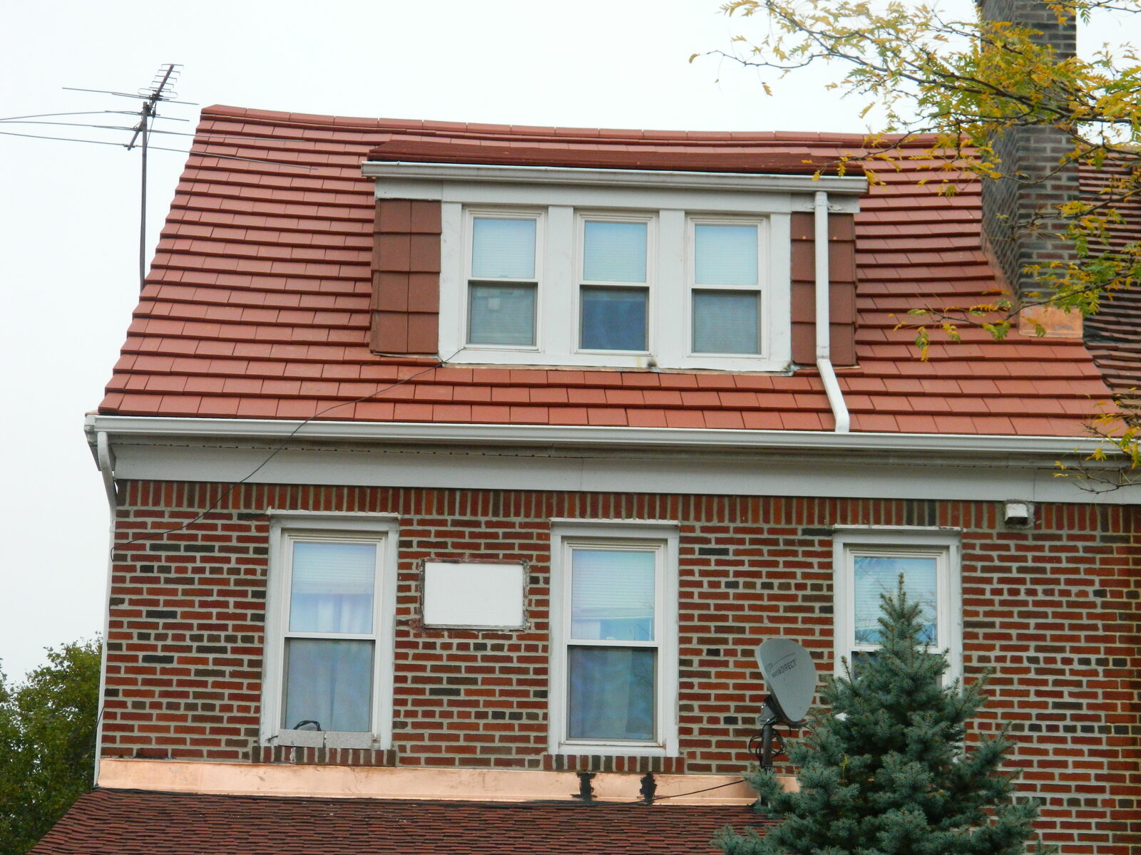 Red-brick home with mansard-style clay tile roof