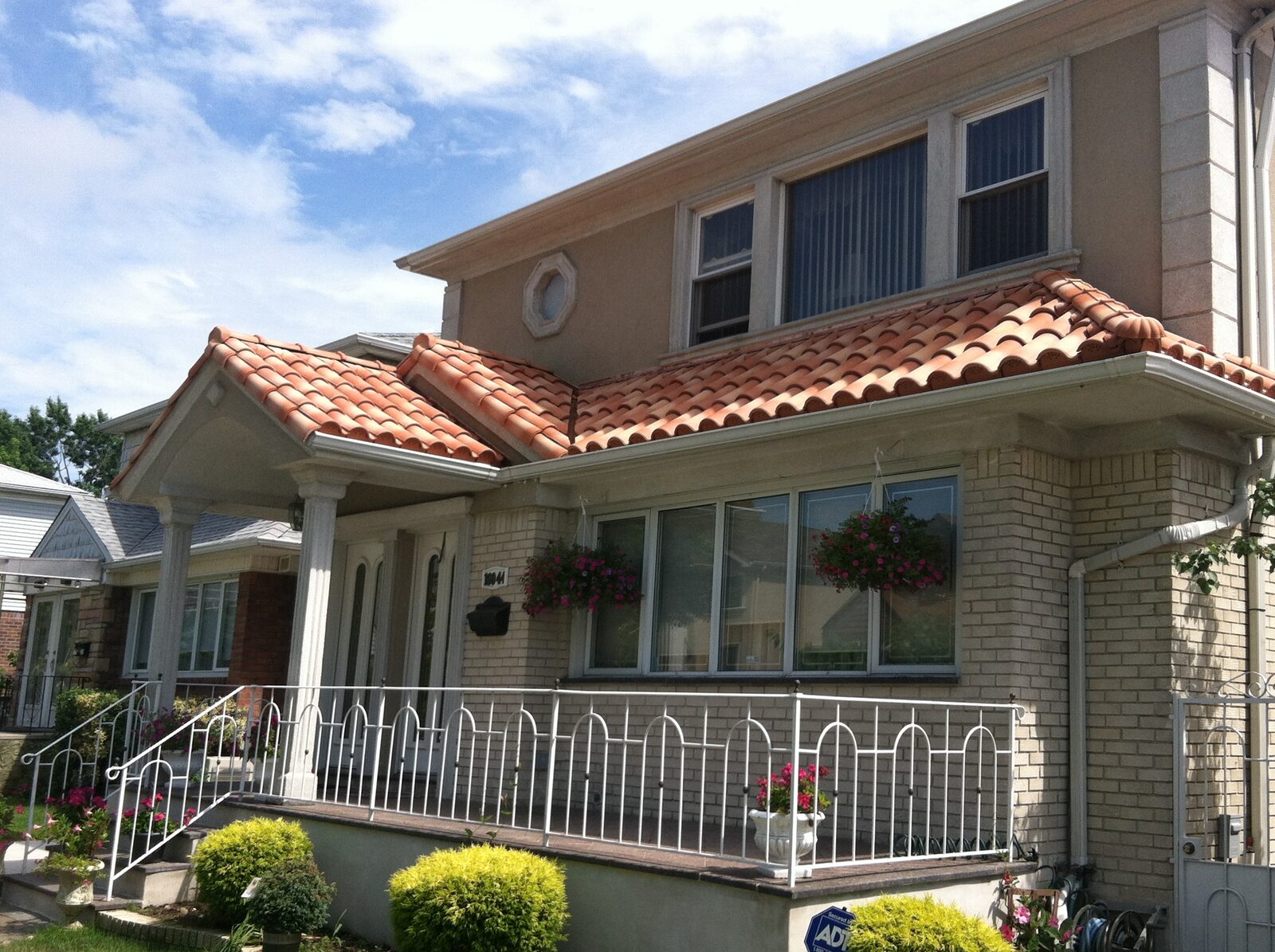 Stucco home with warm terracotta clay tile roof