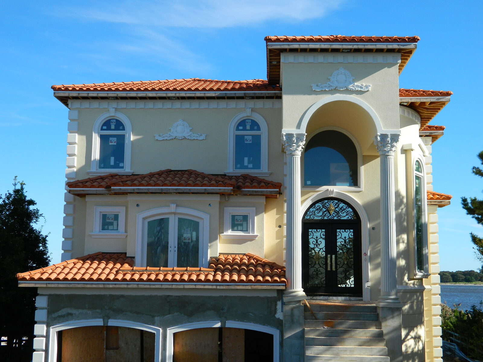 New-construction brick home with red clay tile roof