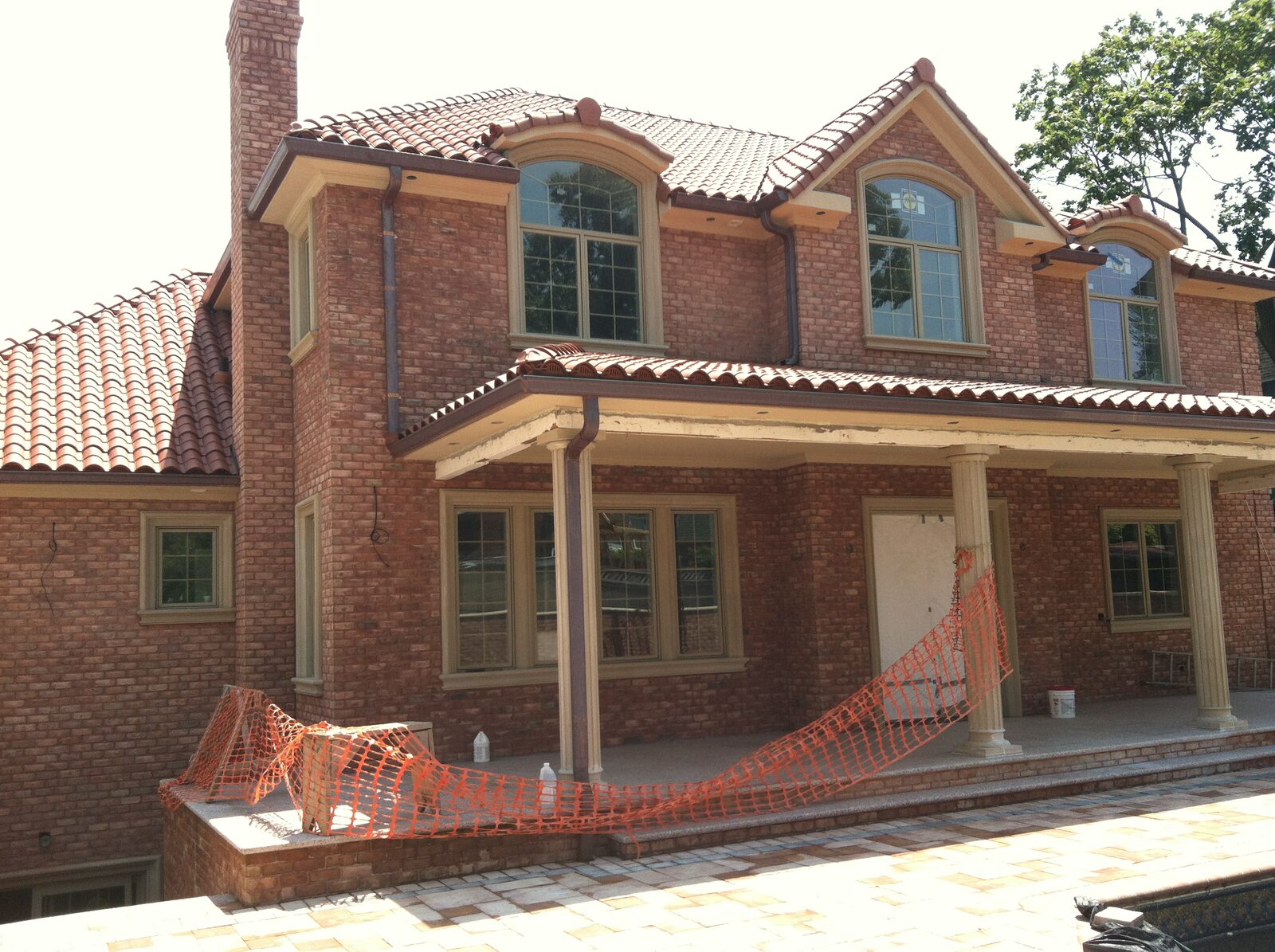Brick home with columns and red clay tile roof