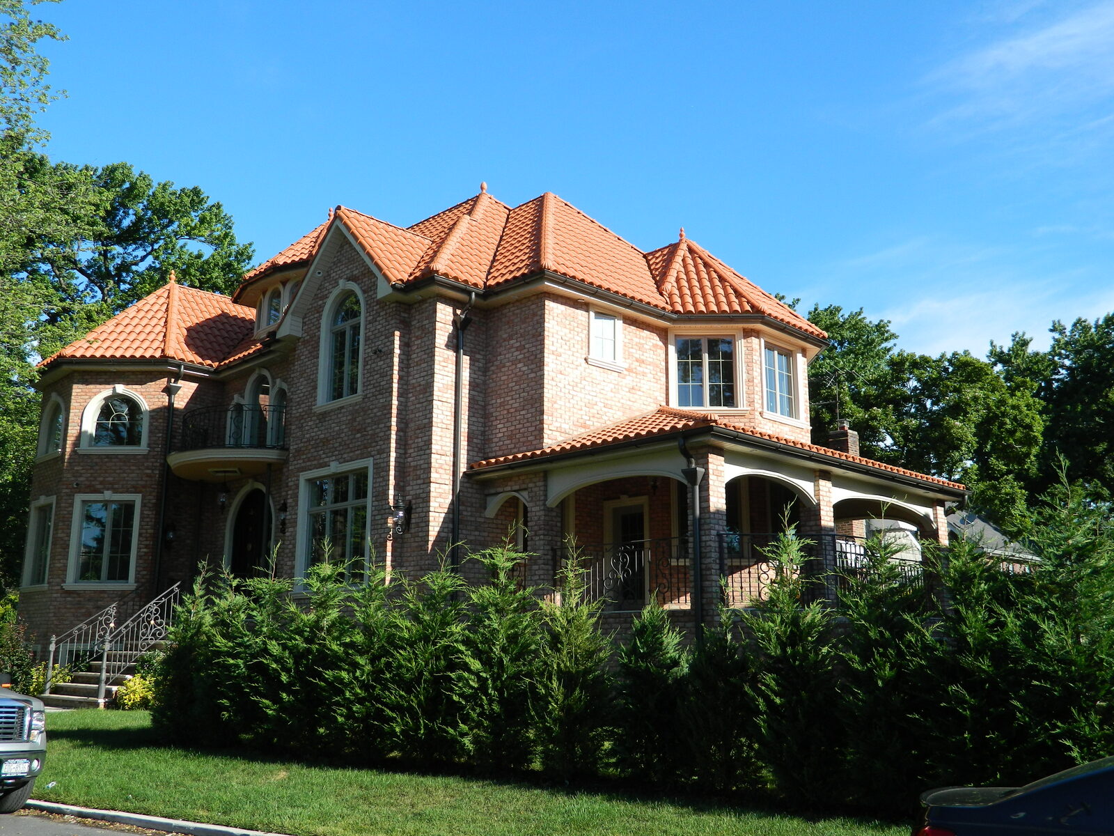 Cream Mediterranean home with arched windows and clay tile roof