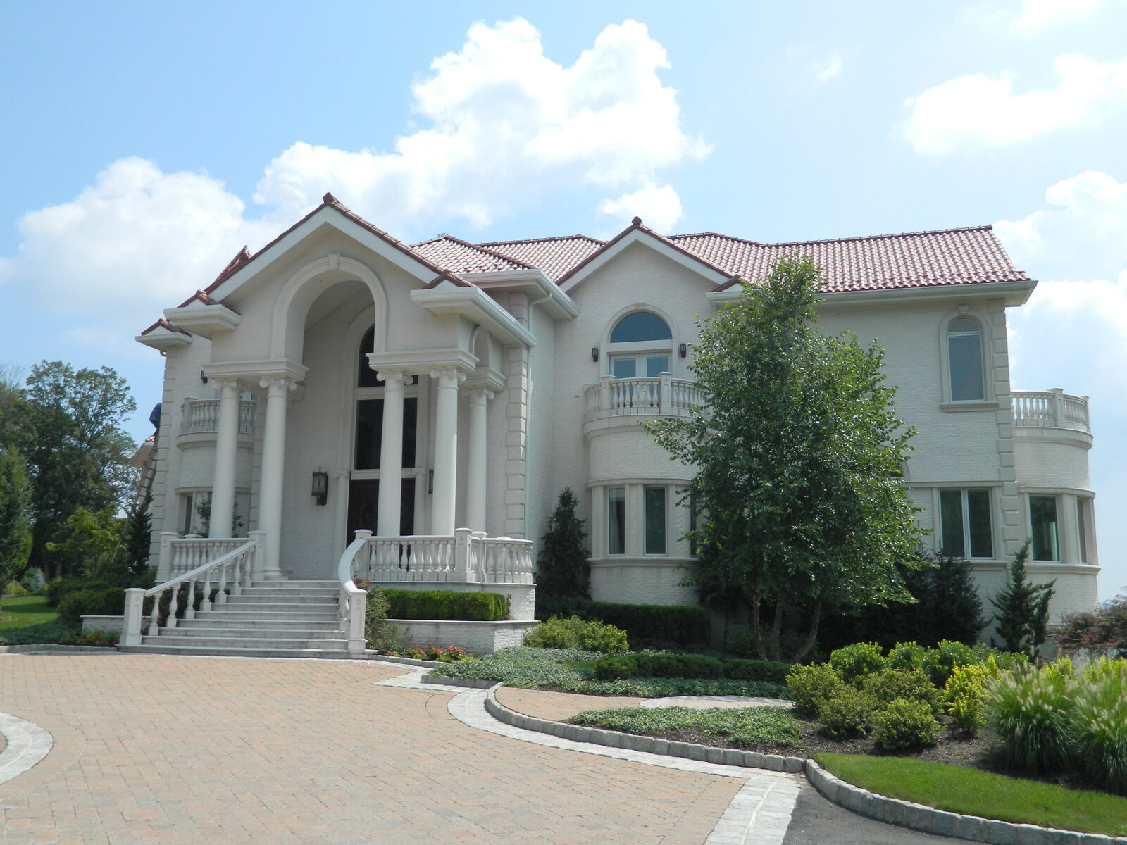 Brick colonial with columns and red clay tile roof