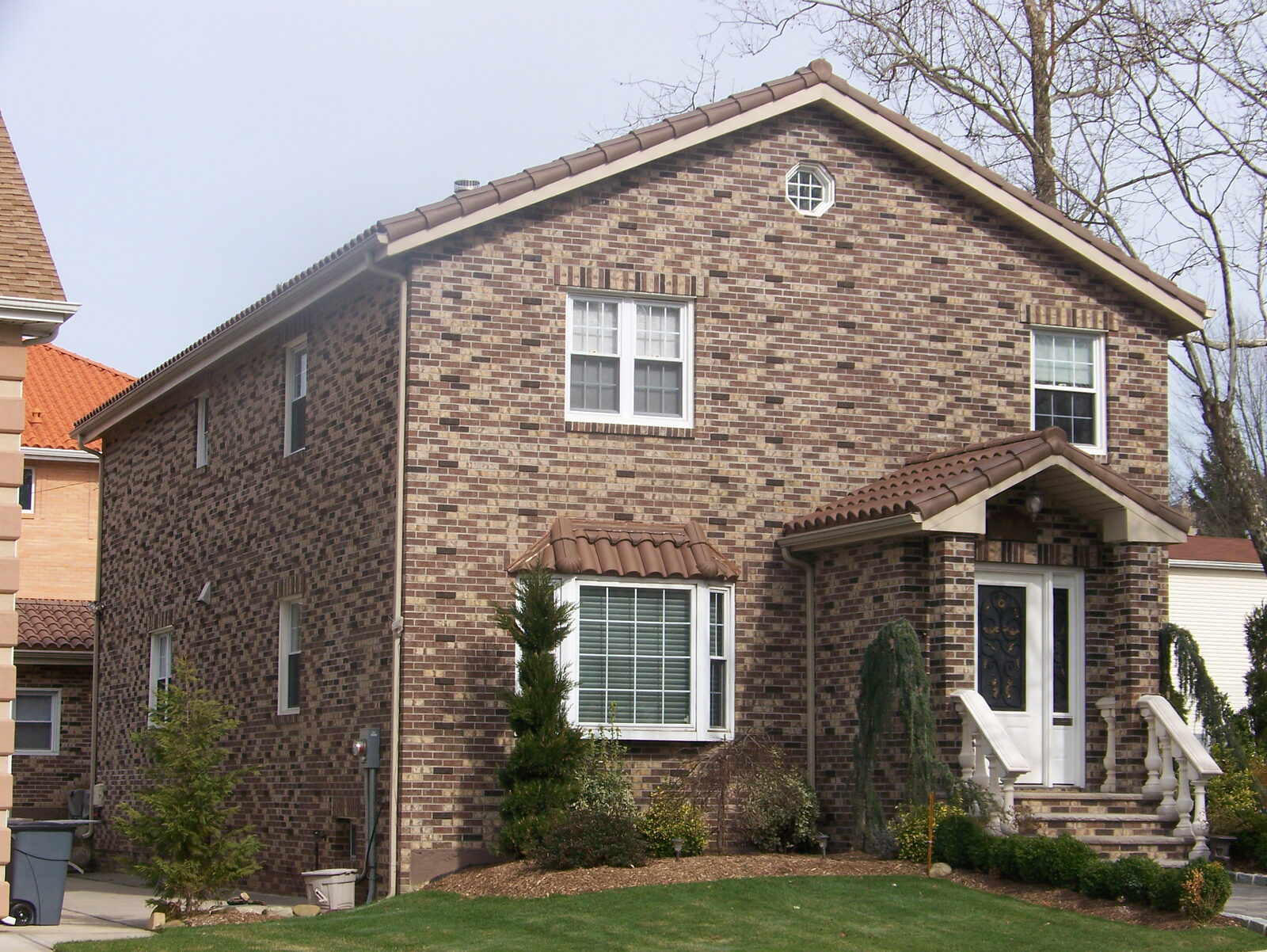 Brick home with dark clay tile roof