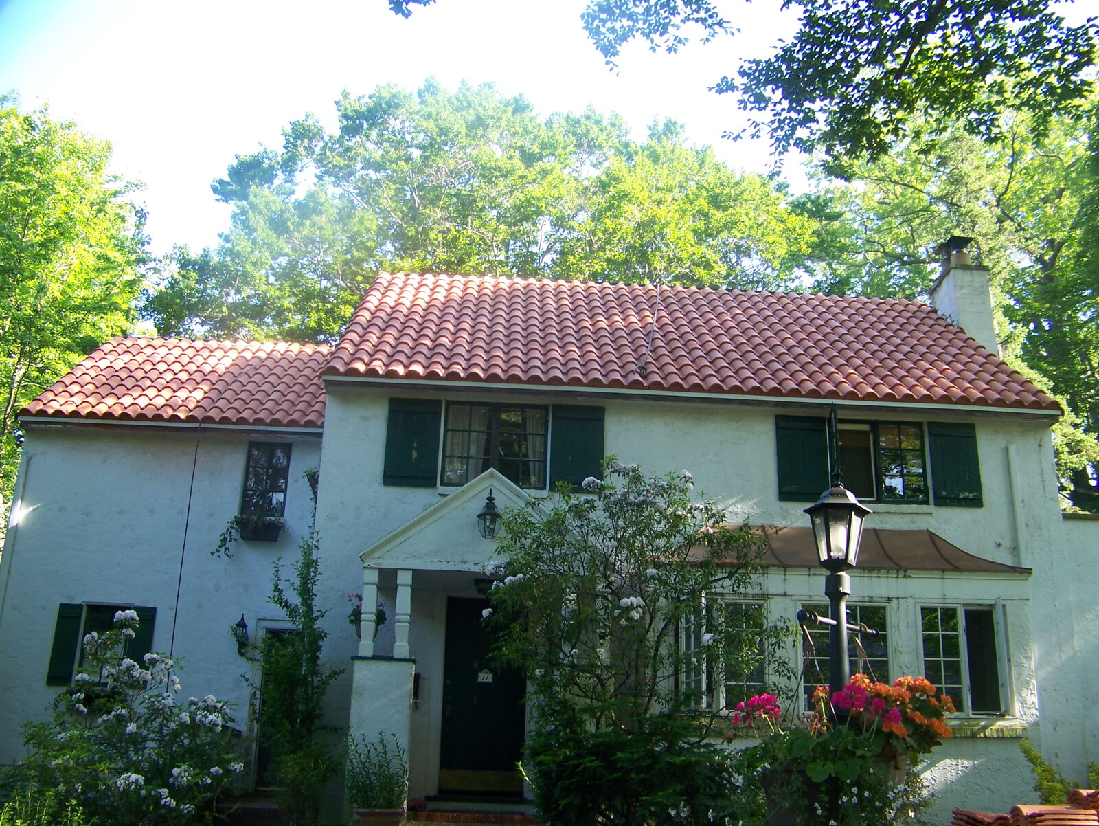 Brick home with white balconies and red clay tile roof