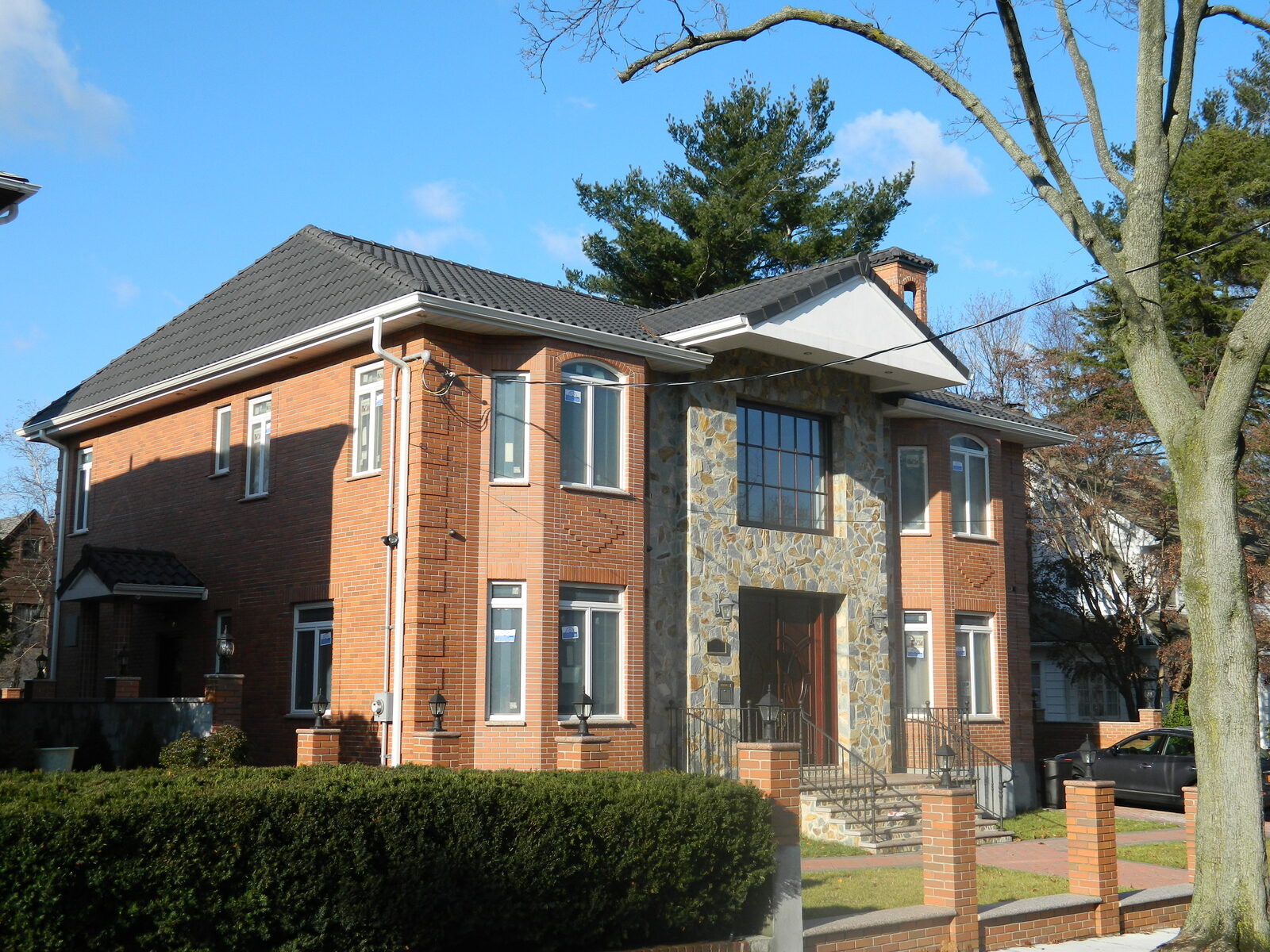Brick home with dark clay tile roof