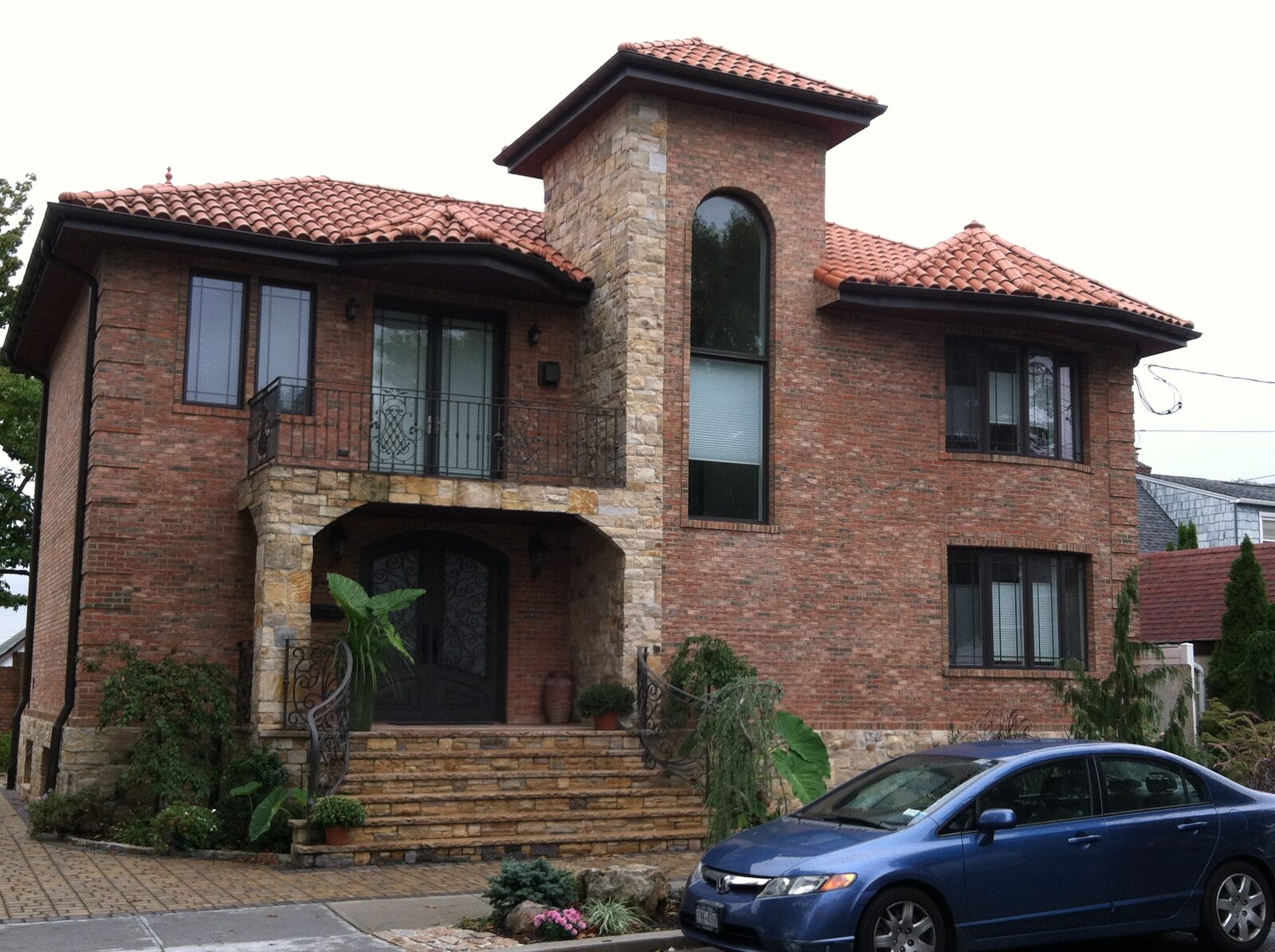 Brick home with arched window and red clay tile roof