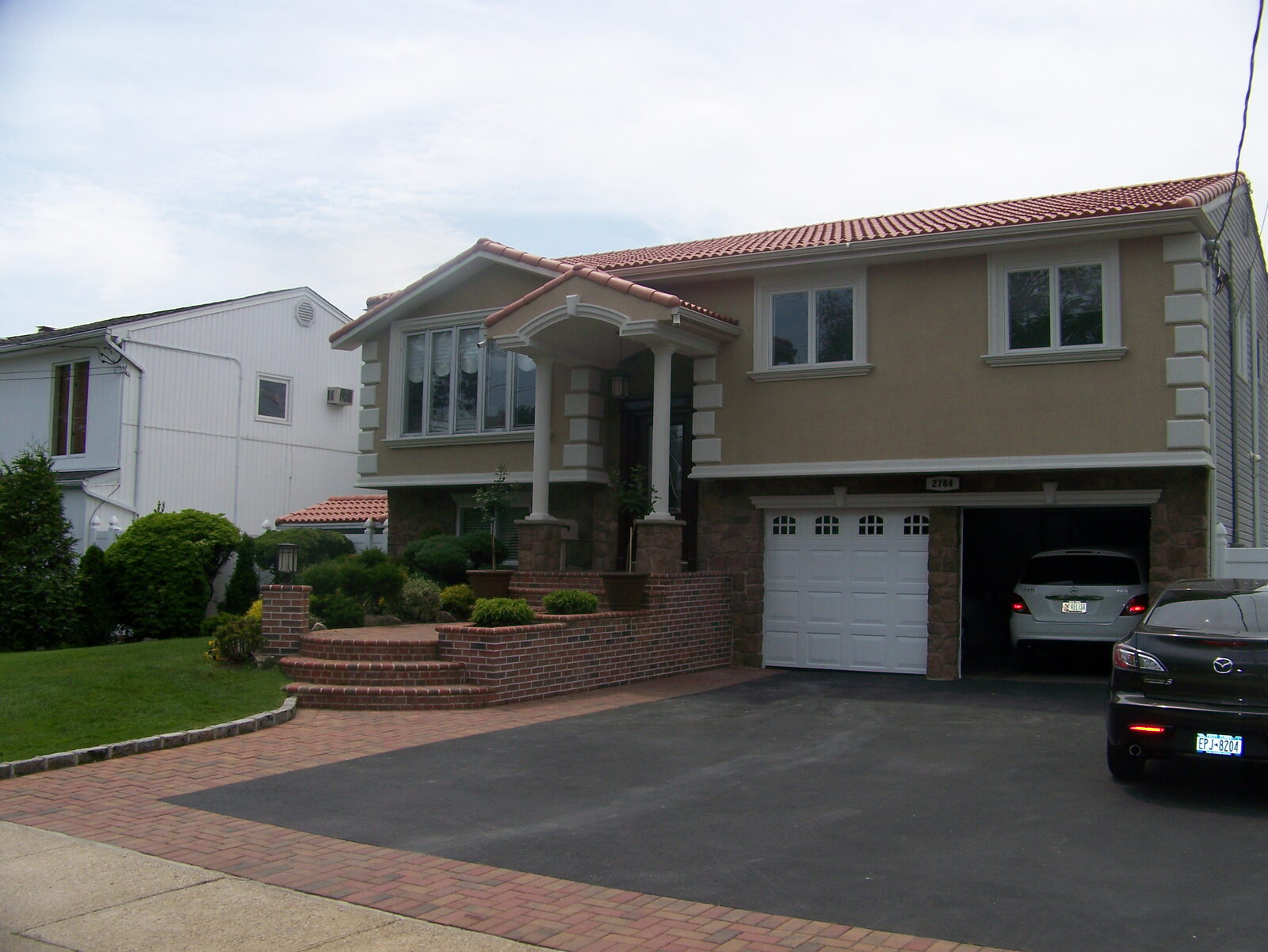 Beige home with columned entry and clay tile roof