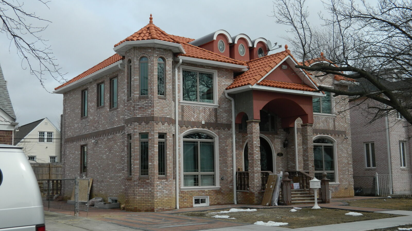 Brick home with corner turret and red clay tile roof