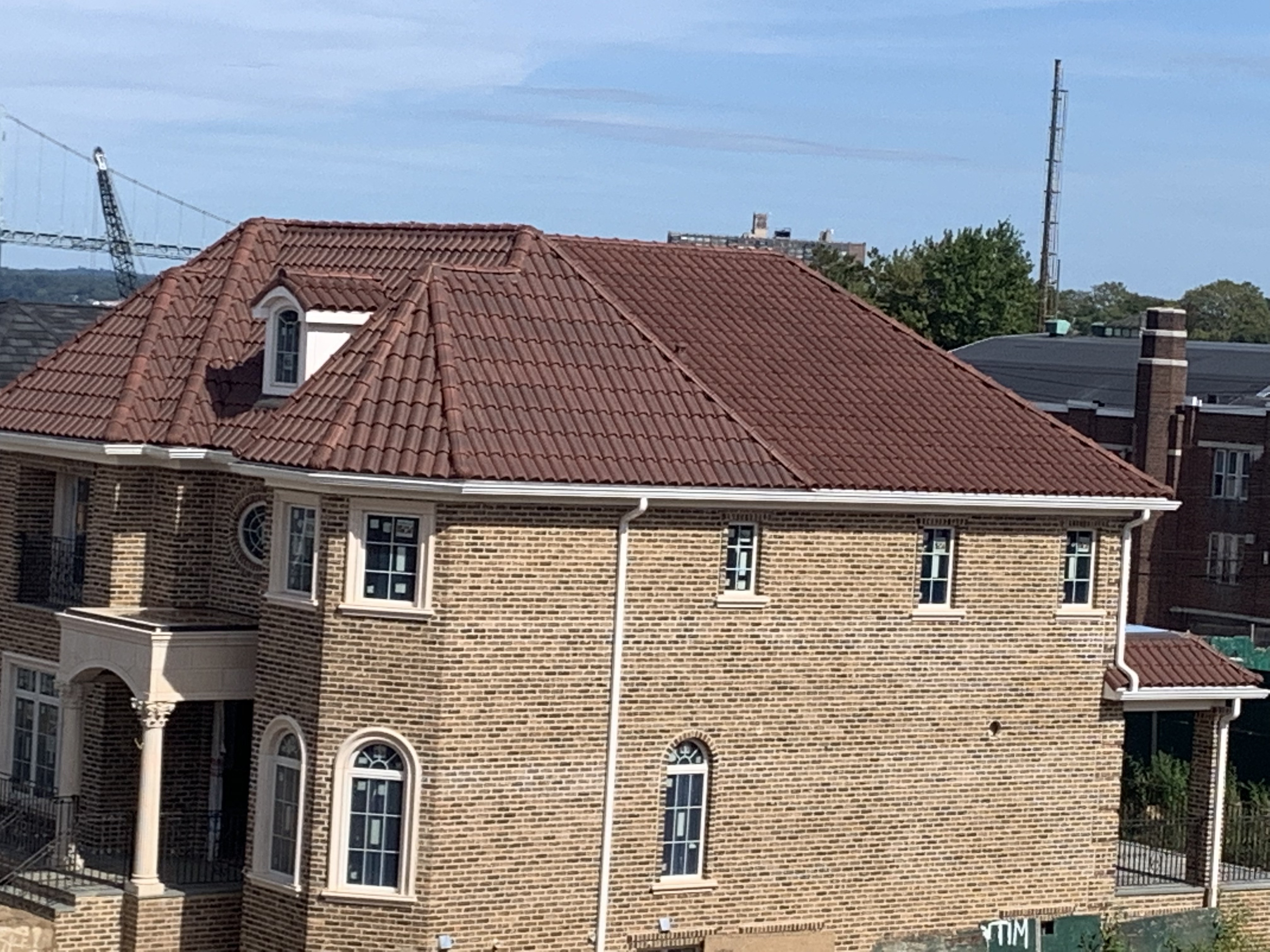 Large brick home with brown clay tile roof