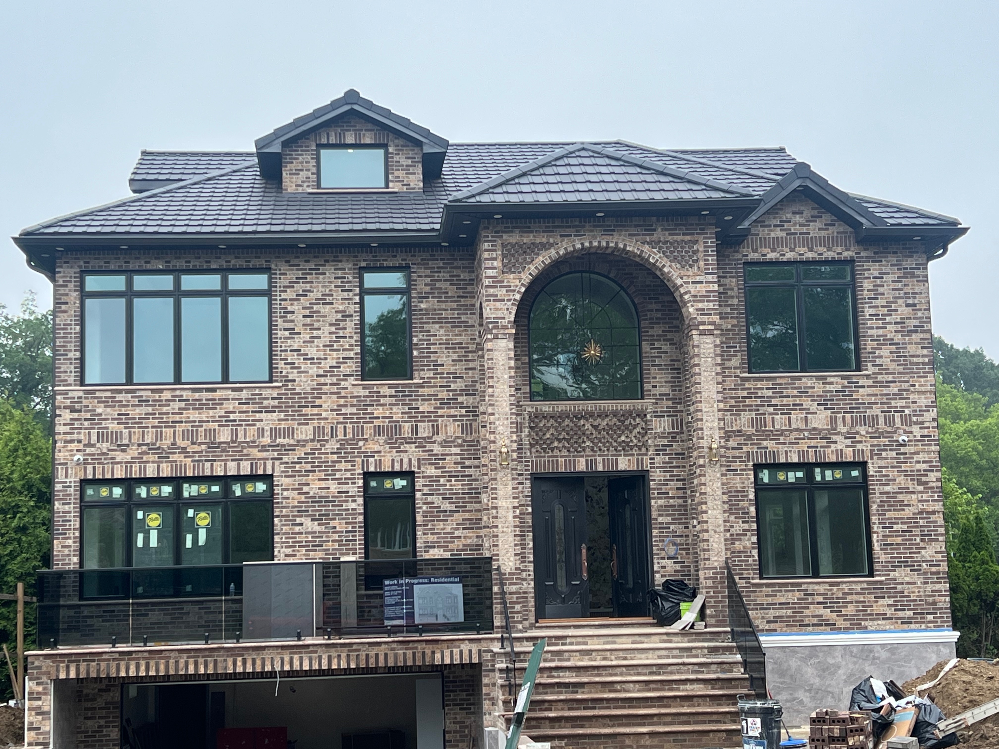Elegant brick home construction featuring modern gray clay tiles and decorative brickwork
